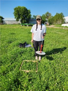OMAFRA Summer Student, Isabella Principe, with a rising plate meter on an Ontario Pasture.